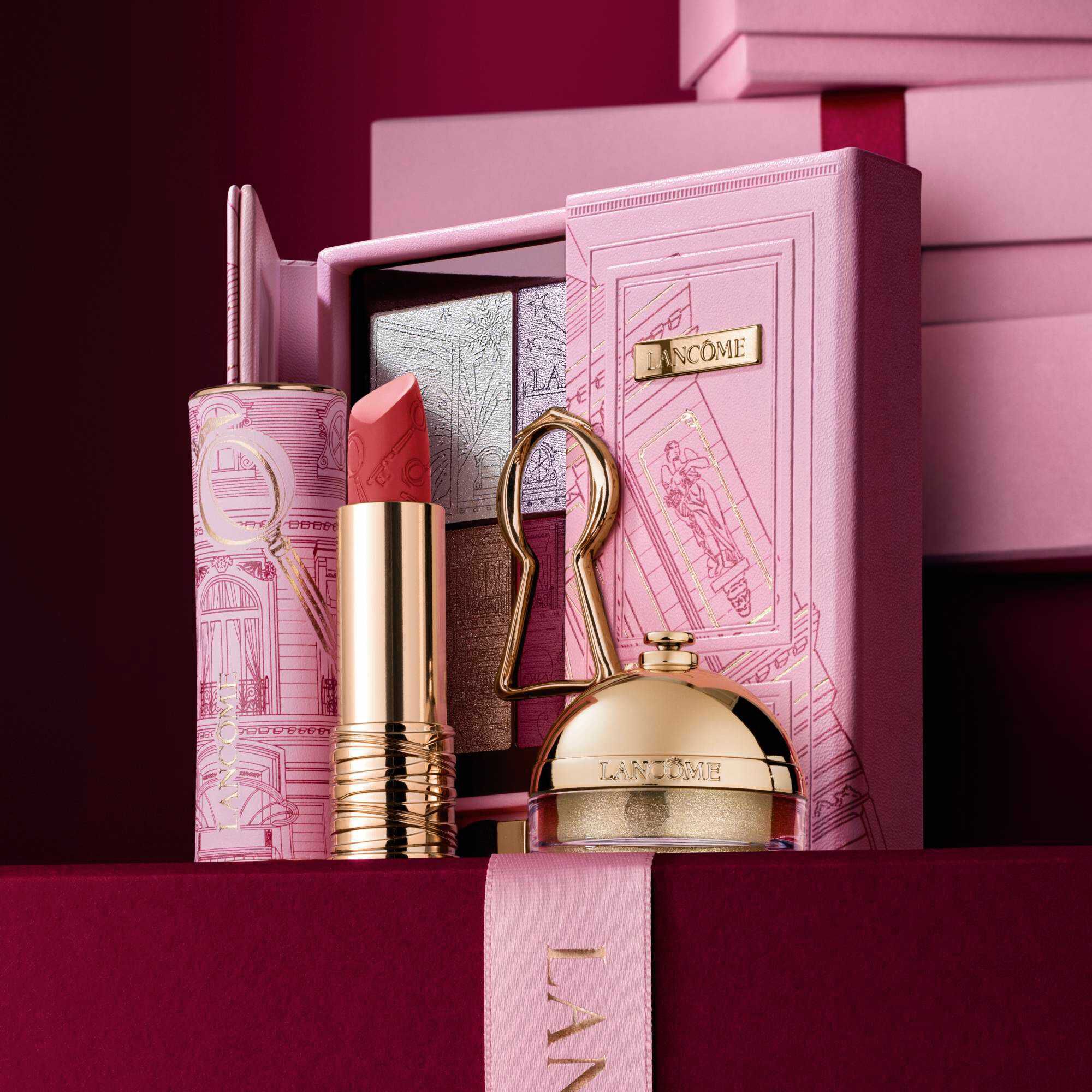 Imagine cu Lipstick Drama mat in ediție limitată, Ring & Shine & The Suite Escape Palette, stand in fața unui teanc de cutii cadou roz și roșu inchis, așezate pe un fundal roșu inchis.