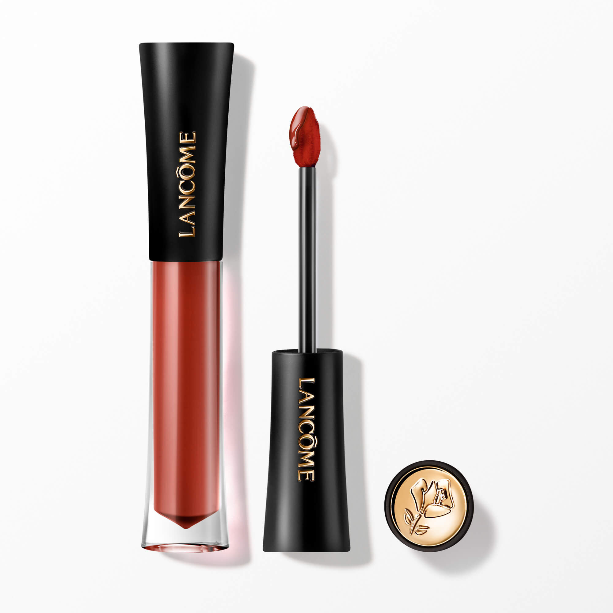 Lip Tint-ul Lancome L'Absolu Rouge Glaze Tintation prezentat cu aplicatorul său și un capacul cu accente aurii și embelmaticul trandafir Lancome.
