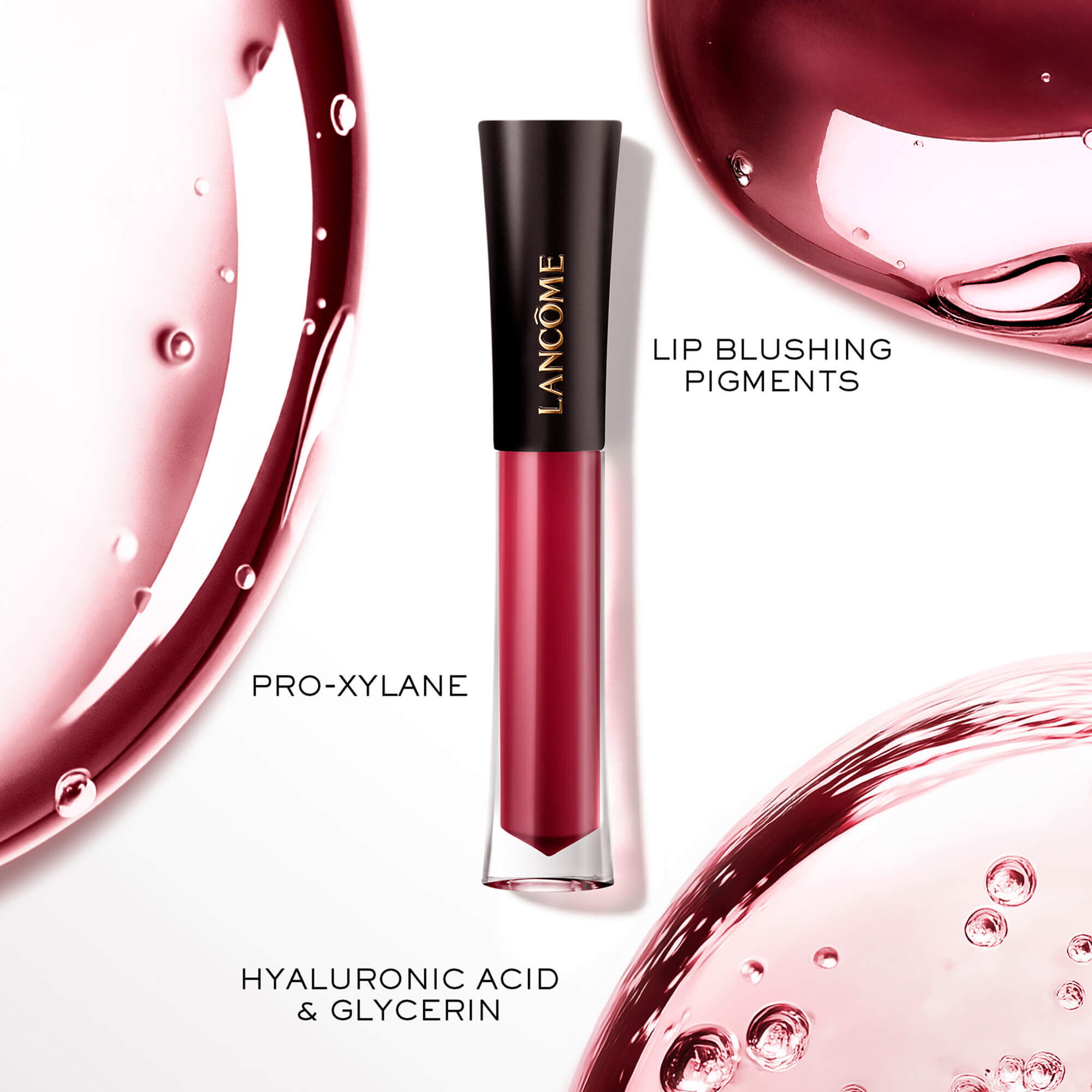 Lip Tint-ul Lancome L'Absolu Rouge Glaze Tintation expus alături de picături artistice de gloss, evidențiind ingredientele cheie: Pro-Xylane, Pigmenți pentru Buze, Acid Hialuronic și Glicerină.
