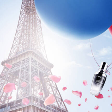 Imaginea prezintă Turnul Eiffel in fundal, cu baloane alb-roșu-albastru plutesc, petale de trandafir și o sticlă de parfum in prim-plan.