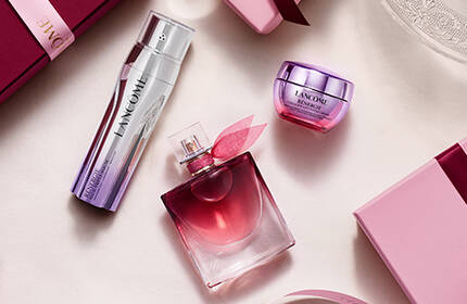 Seturi cadou Lancome de sărbători in cutii roz stil vintage pe un fundal montan inzăpezit.