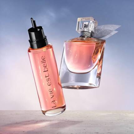 Imagini cu două flacoane de parfum, unul cu eticheta „la vie est belle” și altul cu un capac ornamentat.