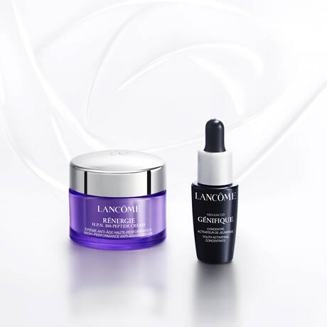Text alternativ: Imaginea prezintă diverse produse cosmetice Lancome, inclusiv parfumuri, seruri, și un ruj, aranjate pe un fundal alb. Mainile interacționează cu unele dintre produse.