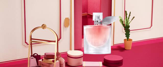 Parfum elegant intr-un decor modern, cu nuanțe de roz și accesorii decorative.