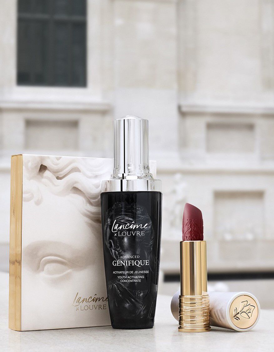 Produse de cosmetică Lancome x Louvre: un ser anti-imbătranire și un ruj intr-o cutie elegantă, amplasate pe un fundal artistic.