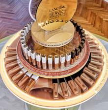 Un stand de produse de machiaj Lancome, cu diverse nuanțe de fond de ten așezate pe un suport rotund, inconjurate de un mesaj despre servicii avansate de analiză a pielii.