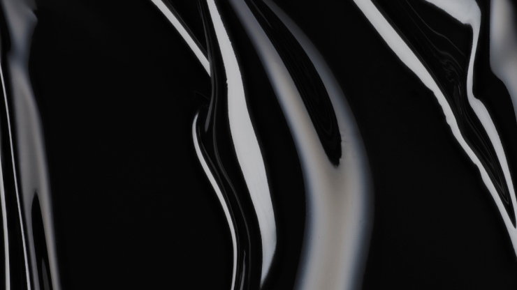 Textura netedă și lucioasă a unei suprafețe negre, cu linii curbe și reflectoare.